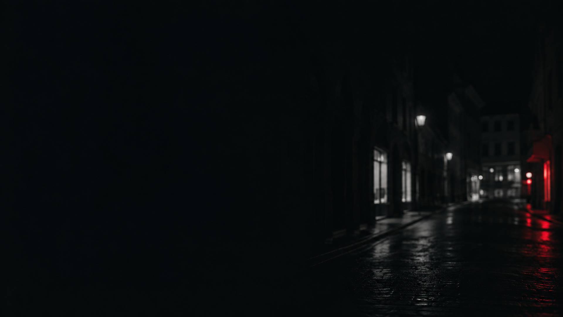 Strada del centro di sera, con il selciato bagnato e qualche vetrina accesa
